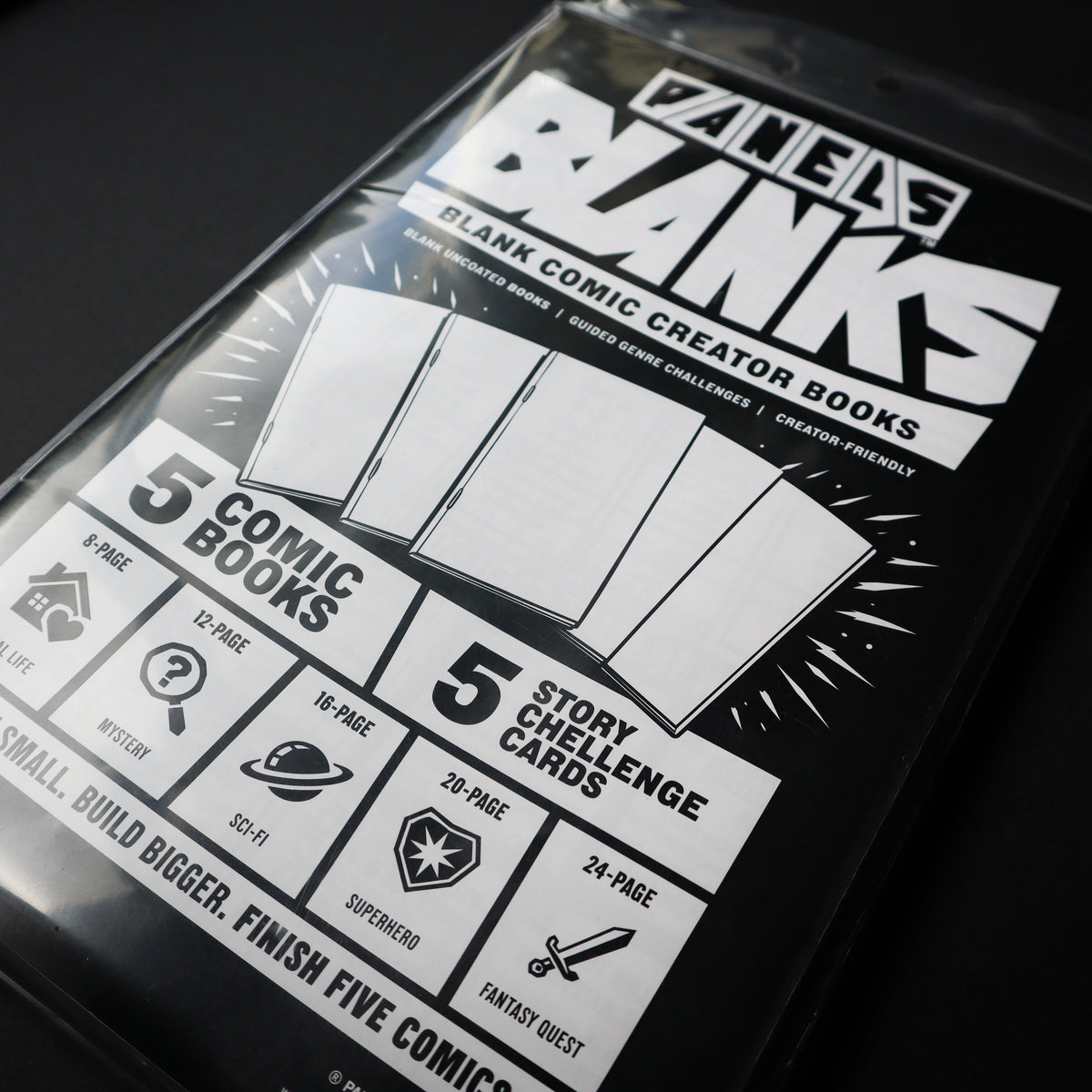 A packaged comic creator book set titled 'PANELS Banks' in a clear plastic sleeve, photographed on a dark background. The front shows bold white title text, a graphic of five blank cards, and feature callouts including '5 comic books' and '5 story challenge cards'.