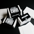 Several stacks of white sketch cards and their black-and-white boxes are arranged on a dark black background. The boxes read 'PANELS SKETCH CARDS' and 'ARCHIVAL SKETCH CARDS' with '100 CARDS' visible.